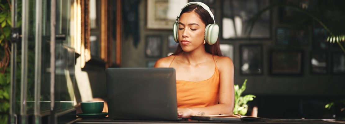 Student, headphones and laptop with woman in cafe on campus for college research, education or lear
