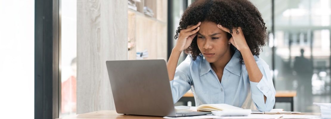 Bored workaholic accountant employee with headache and stress. Black woman overwork at office