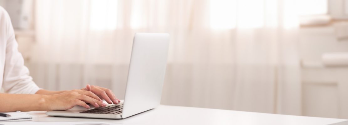 Unrecognizable Woman Using Laptop Typing Article Working In Office, Cropped