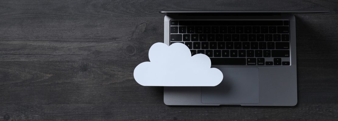 White paper cloud with laptop on black table background