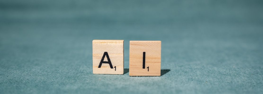 AI wooden letter tiles on green background.