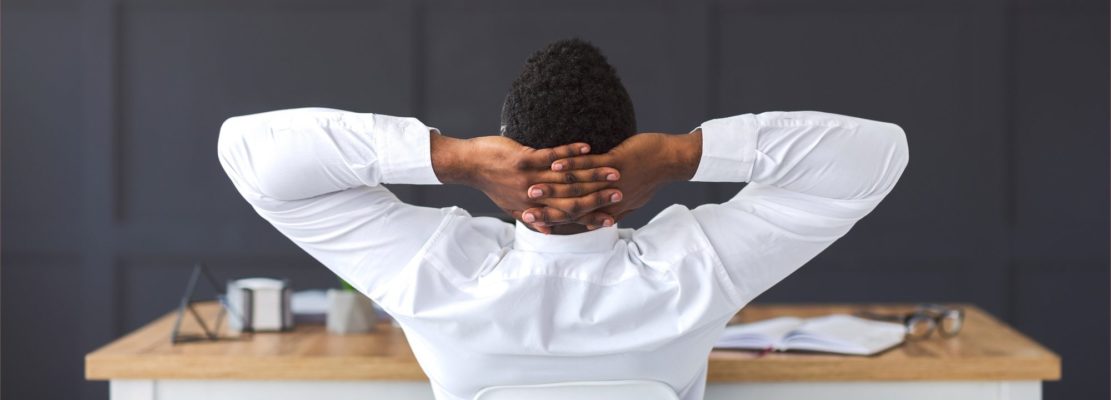 Rear view of african employee relaxing in office