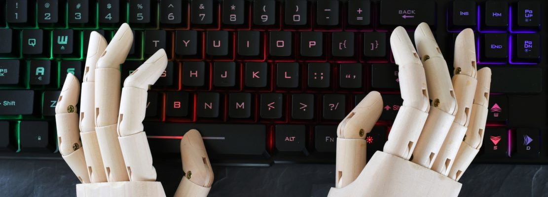 AI artificial intelligence concept - robot hands typing on lit keyboard