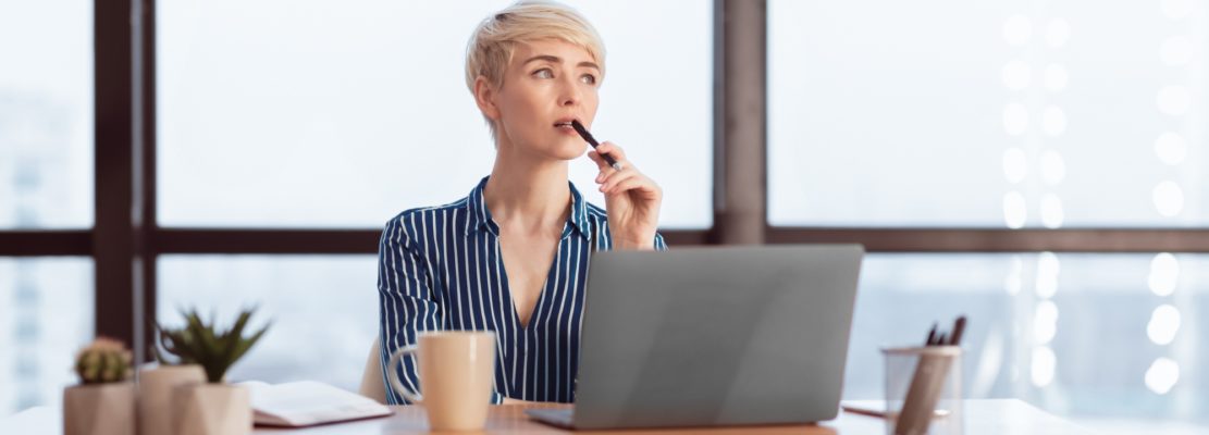 Pensive Businesswoman At Laptop Thinking On A Task In Office