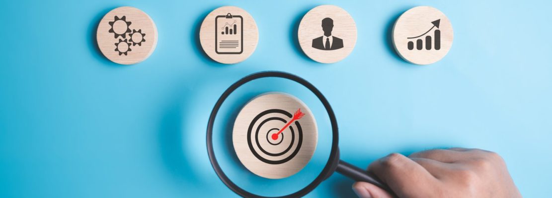 Magnifying glass with target business icons