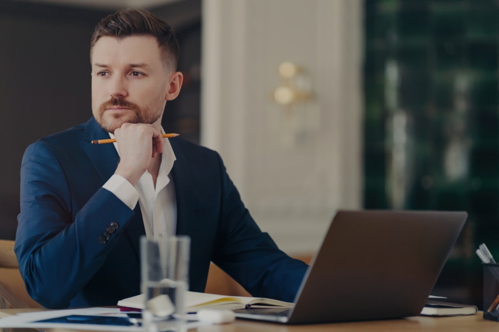 8 Tipps, mit denen Sie das ideale LMS für Ihr eLearning-Kursformat auswählen können 2 Serious male entrepreneur in blue suit, stylish office, thinking about business challenges